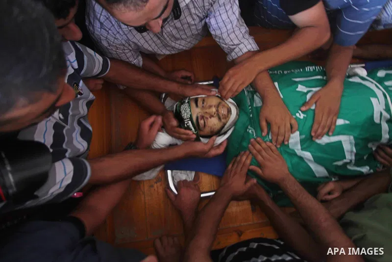 Palestinians carry the body of Hamas militant Hamam Abu Qadus during his funeral in Gaza City June 23, 2012. Israel launched air raids early on Saturday against three Hamas security targets in the Gaza Strip, wounding at...