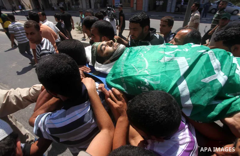 Palestinians carry the body of Hamas militant Hamam Abu Qadus during his funeral in Gaza City June 23, 2012. Israel launched air raids early on Saturday against three Hamas security targets in the Gaza Strip, wounding at...