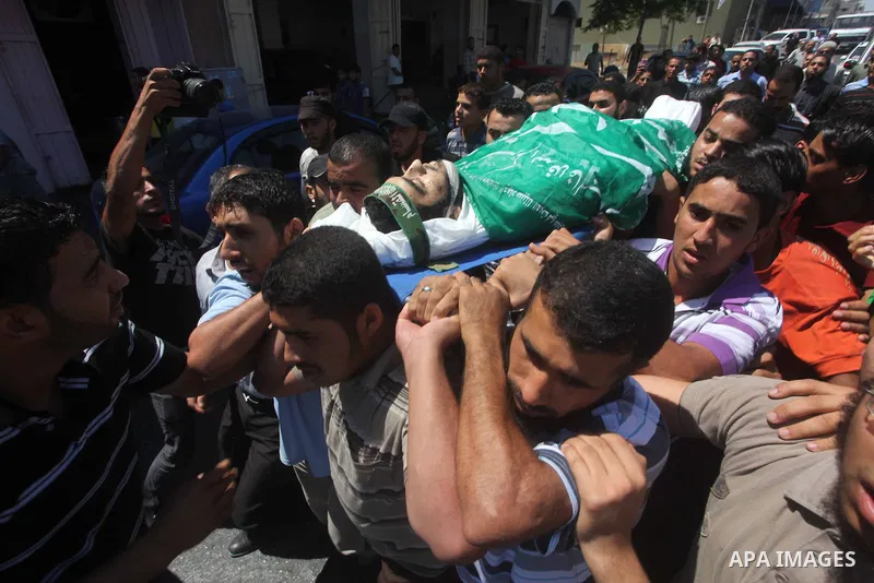 Palestinians carry the body of Hamas militant Hamam Abu Qadus during his funeral in Gaza City June 23, 2012. Israel launched air raids early on Saturday against three Hamas security targets in the Gaza Strip, wounding at...