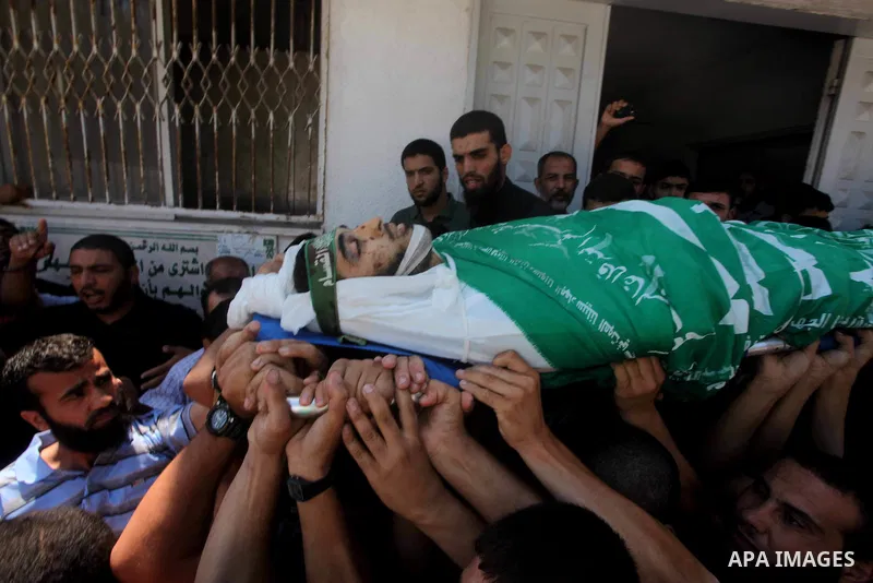 Palestinians carry the body of Hamas militant Hamam Abu Qadus during his funeral in Gaza City June 23, 2012. Israel launched air raids early on Saturday against three Hamas security targets in the Gaza Strip, wounding at...