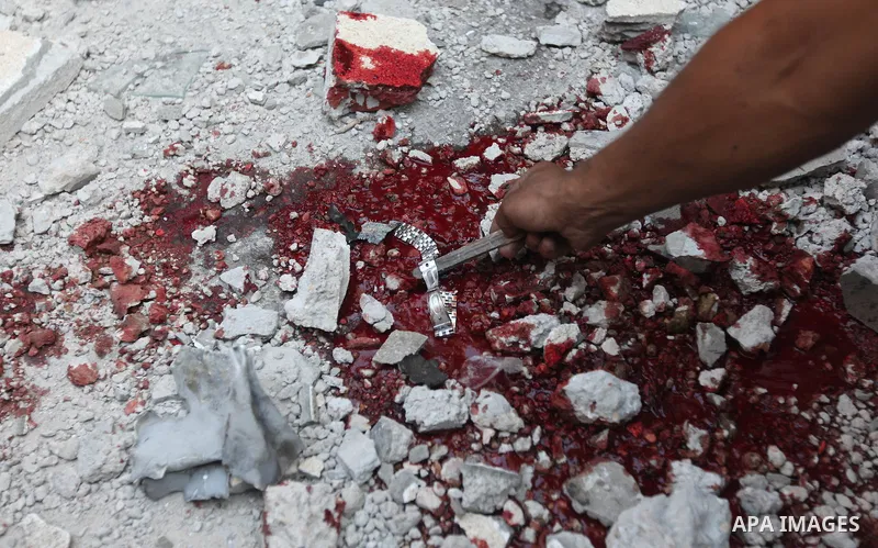Palestinian children stand looking at the blood stained street following an Israeli strike on Gaza City on June 23, 2012. A Palestinian teenager riding a motorcycle was killed and 10 passers-by wounded in a fresh Israeli...