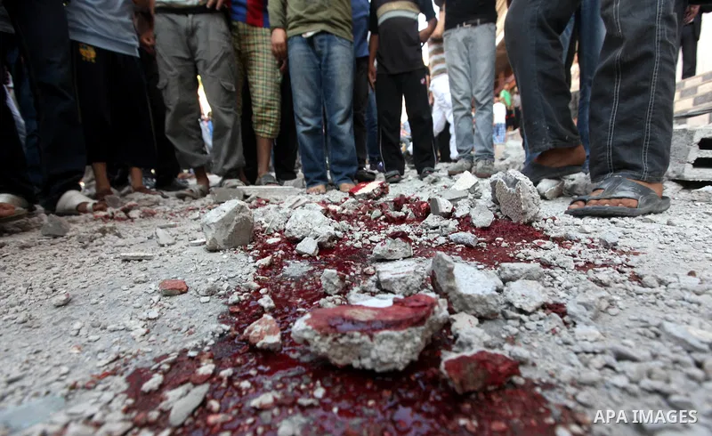 Palestinian children stand looking at the blood stained street following an Israeli strike on Gaza City on June 23, 2012. A Palestinian teenager riding a motorcycle was killed and 10 passers-by wounded in a fresh Israeli...