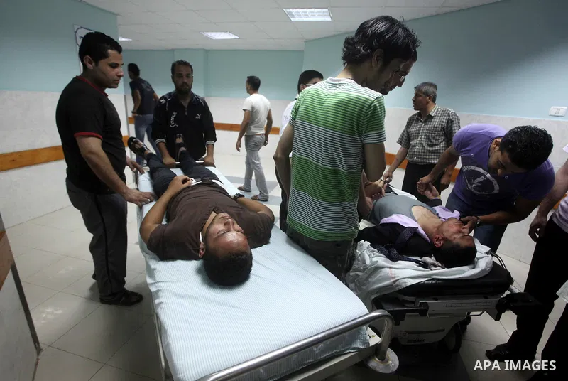 Palestinians wheel a wounded man at a hospital in Gaza City, following an Israeli air strike June 23, 2012. Israeli air strikes on Hamas security targets in Gaza killed two Palestinians and wounded 30 people on Saturday,...