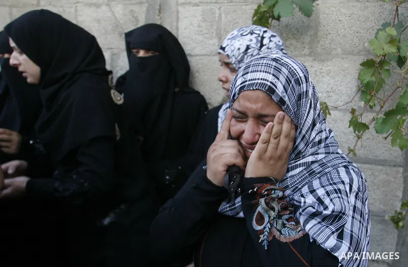 Palestinian relatives mourn during the funeral procession of six-year-old Ali al-Shwaf in Khan Younis, in the southern Gaza Strip on June 23, 2012, after he was killed during an Israeli air strike in Gaza and his father...