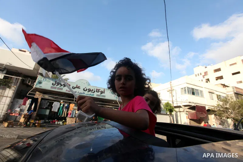 Palestinians hold national and Egyptian flags as they celebrate in Gaza City, the victory of Muslim Brotherhood's presidential candidate, Mohamed Morsi, in the Egyptian elections on June 24, 2012. Arab governments and le...