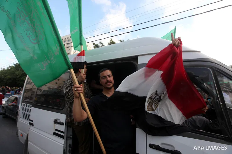 Palestinians hold national and Egyptian flags as they celebrate in Gaza City, the victory of Muslim Brotherhood's presidential candidate, Mohamed Morsi, in the Egyptian elections on June 24, 2012. Arab governments and le...