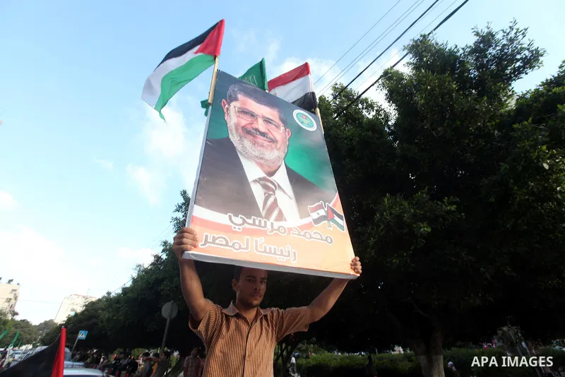 Palestinians hold national and Egyptian flags as they celebrate in Gaza City, the victory of Muslim Brotherhood's presidential candidate, Mohamed Morsi, in the Egyptian elections on June 24, 2012. Arab governments and le...