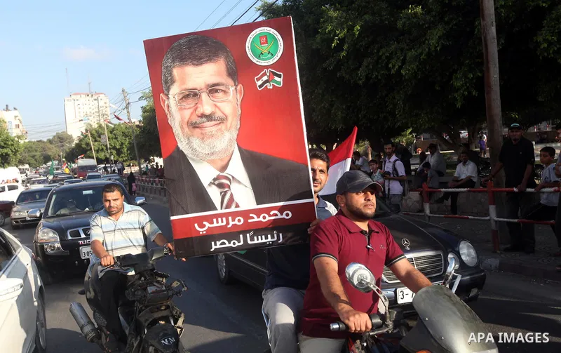 Palestinians hold national and Egyptian flags as they celebrate in Gaza City, the victory of Muslim Brotherhood's presidential candidate, Mohamed Morsi, in the Egyptian elections on June 24, 2012. Arab governments and le...