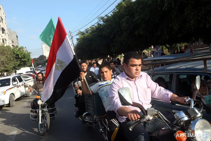 Palestinians hold national and Egyptian flags as they celebrate in Gaza City, the victory of Muslim Brotherhood's presidential candidate, Mohamed Morsi, in the Egyptian elections on June 24, 2012. Arab governments and le...