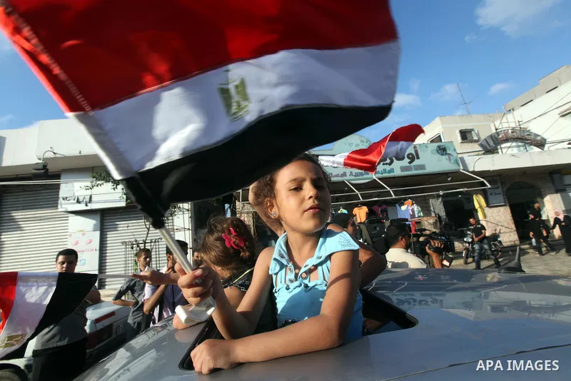Palestinians hold national and Egyptian flags as they celebrate in Gaza City, the victory of Muslim Brotherhood's presidential candidate, Mohamed Morsi, in the Egyptian elections on June 24, 2012. Arab governments and le...