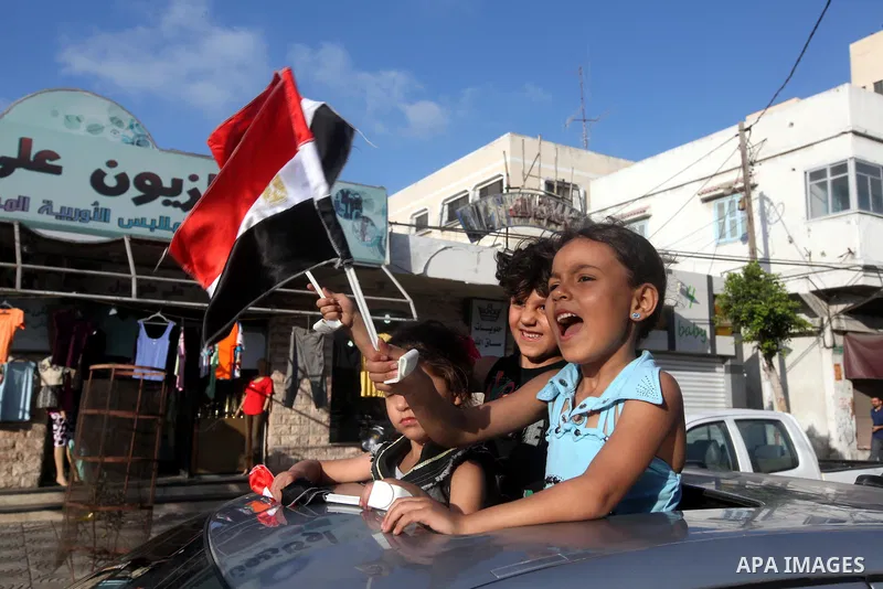 Palestinians hold national and Egyptian flags as they celebrate in Gaza City, the victory of Muslim Brotherhood's presidential candidate, Mohamed Morsi, in the Egyptian elections on June 24, 2012. Arab governments and le...