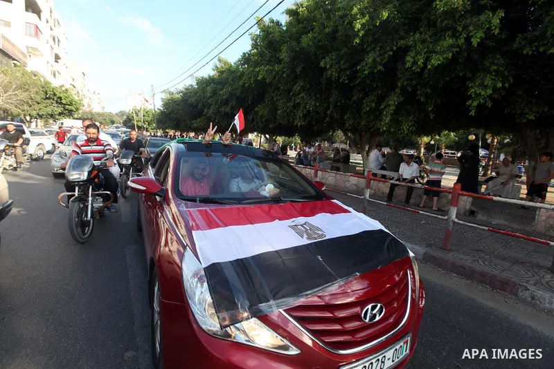 Palestinians hold national and Egyptian flags as they celebrate in Gaza City, the victory of Muslim Brotherhood's presidential candidate, Mohamed Morsi, in the Egyptian elections on June 24, 2012. Arab governments and le...