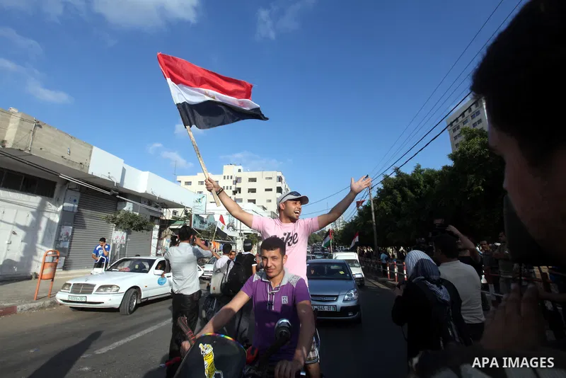 Palestinians hold national and Egyptian flags as they celebrate in Gaza City, the victory of Muslim Brotherhood's presidential candidate, Mohamed Morsi, in the Egyptian elections on June 24, 2012. Arab governments and le...