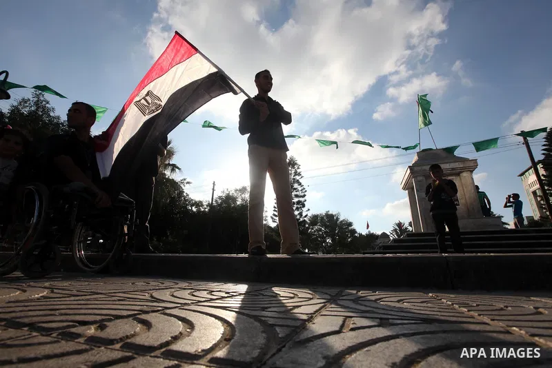 Palestinians hold national and Egyptian flags as they celebrate in Gaza City, the victory of Muslim Brotherhood's presidential candidate, Mohamed Morsi, in the Egyptian elections on June 24, 2012. Arab governments and le...