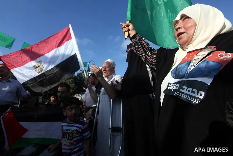 Palestinians hold national and Egyptian flags as they celebrate in Gaza City, the victory of Muslim Brotherhood's presidential candidate, Mohamed Morsi, in the Egyptian elections on June 24, 2012. Arab governments and le...