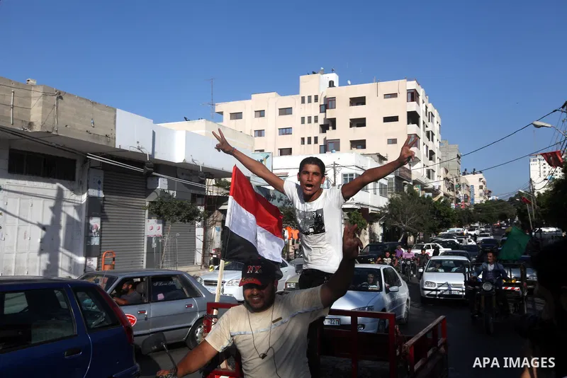 Palestinians hold national and Egyptian flags as they celebrate in Gaza City, the victory of Muslim Brotherhood's presidential candidate, Mohamed Morsi, in the Egyptian elections on June 24, 2012. Arab governments and le...