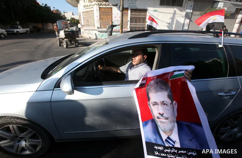 Palestinians hold national and Egyptian flags as they celebrate in Gaza City, the victory of Muslim Brotherhood's presidential candidate, Mohamed Morsi, in the Egyptian elections on June 24, 2012. Arab governments and le...