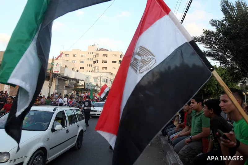 Palestinians hold national and Egyptian flags as they celebrate in Gaza City, the victory of Muslim Brotherhood's presidential candidate, Mohamed Morsi, in the Egyptian elections on June 24, 2012. Arab governments and le...