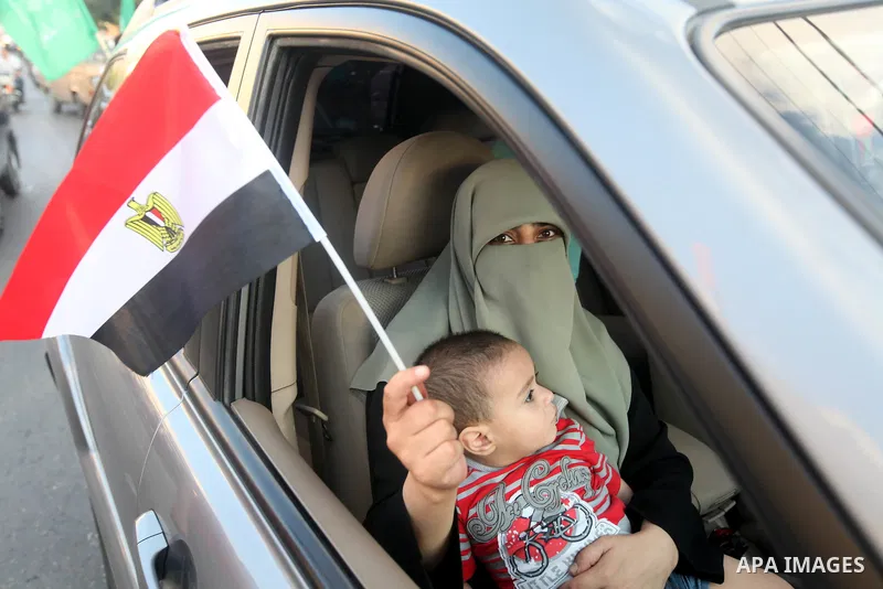 Palestinians hold national and Egyptian flags as they celebrate in Gaza City, the victory of Muslim Brotherhood's presidential candidate, Mohamed Morsi, in the Egyptian elections on June 24, 2012. Arab governments and le...