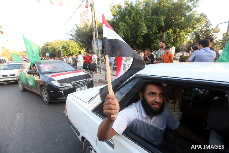 Palestinians hold national and Egyptian flags as they celebrate in Gaza City, the victory of Muslim Brotherhood's presidential candidate, Mohamed Morsi, in the Egyptian elections on June 24, 2012. Arab governments and le...