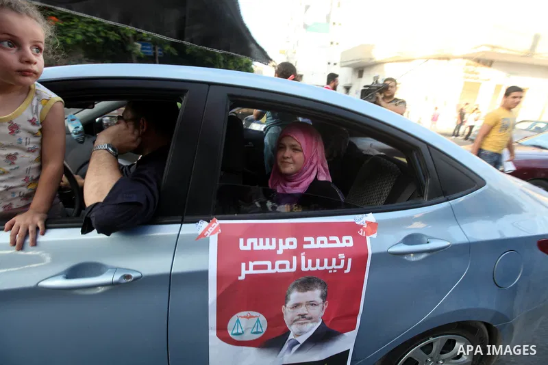 Palestinians hold national and Egyptian flags as they celebrate in Gaza City, the victory of Muslim Brotherhood's presidential candidate, Mohamed Morsi, in the Egyptian elections on June 24, 2012. Arab governments and le...