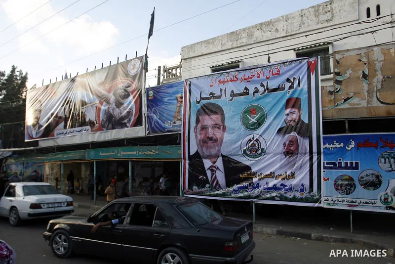 Palestinians hold national and Egyptian flags as they celebrate in Rafah town, in the southern Gaza Strip, the victory of the Muslim Brotherhood's presidential candidate, Mohamed Morsi in the Egyptian presidential electi...