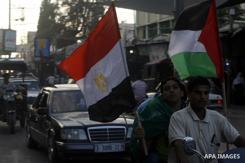 Palestinians hold national and Egyptian flags as they celebrate in Rafah town, in the southern Gaza Strip, the victory of the Muslim Brotherhood's presidential candidate, Mohamed Morsi in the Egyptian presidential electi...
