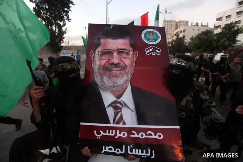 Hamas militants hold a poster depicting Mohamed Morsy of the Muslim Brotherhood after the Egyptian Presidential election committee announced him as victor. The Muslim Brotherhood's Mohammed Morsi became Egypt's first fre...