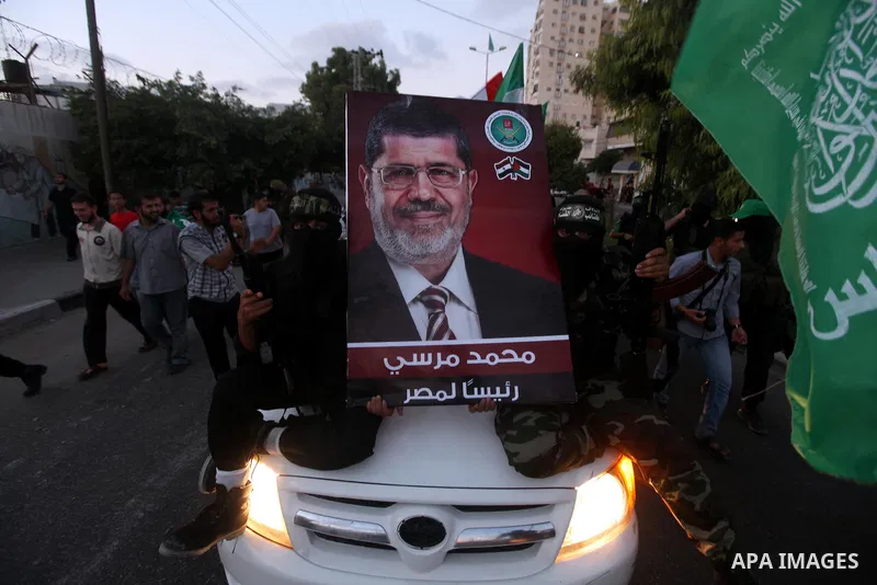 Hamas militants hold a poster depicting Mohamed Morsy of the Muslim Brotherhood after the Egyptian Presidential election committee announced him as victor. The Muslim Brotherhood's Mohammed Morsi became Egypt's first fre...