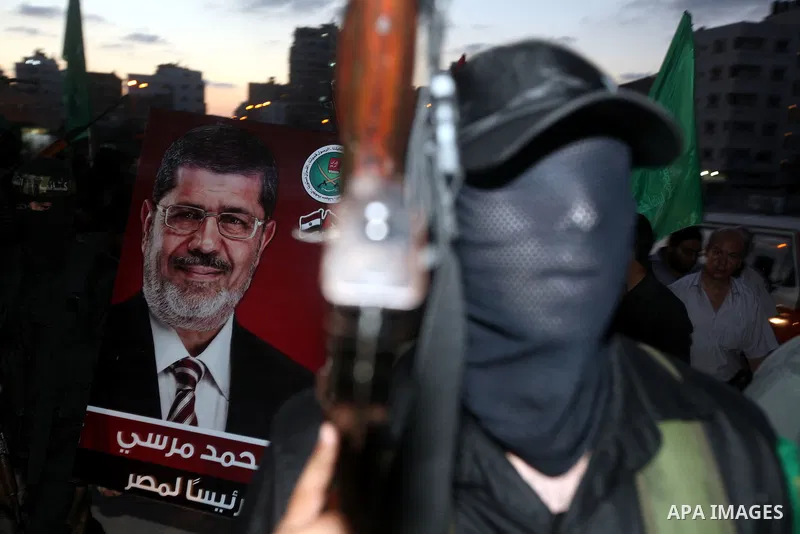Hamas militants hold a poster depicting Mohamed Morsy of the Muslim Brotherhood after the Egyptian Presidential election committee announced him as victor. The Muslim Brotherhood's Mohammed Morsi became Egypt's first fre...