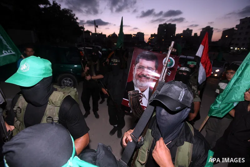 Hamas militants hold a poster depicting Mohamed Morsy of the Muslim Brotherhood after the Egyptian Presidential election committee announced him as victor. The Muslim Brotherhood's Mohammed Morsi became Egypt's first fre...