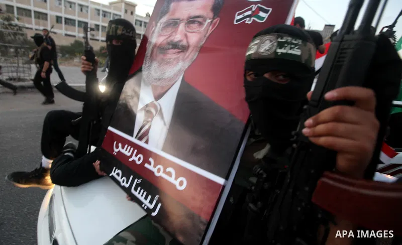 Hamas militants hold a poster depicting Mohamed Morsy of the Muslim Brotherhood after the Egyptian Presidential election committee announced him as victor. The Muslim Brotherhood's Mohammed Morsi became Egypt's first fre...
