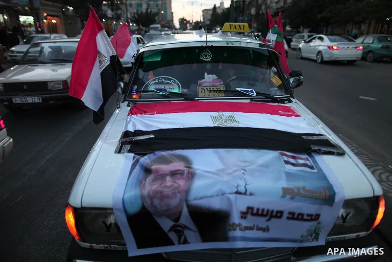 Palestinians hold national and Egyptian flags as they celebrate in Gaza City, the victory of Muslim Brotherhood's presidential candidate, Mohamed Morsi, in the Egyptian elections on June 24, 2012. Arab governments and le...