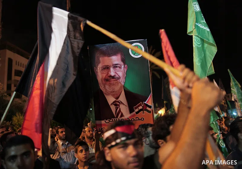 Palestinians hold national and Egyptian flags as they celebrate in Gaza City, the victory of Muslim Brotherhood's presidential candidate, Mohamed Morsi, in the Egyptian elections on June 24, 2012. Arab governments and le...