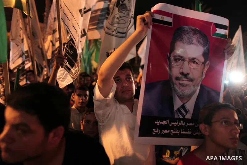 Palestinians hold national and Egyptian flags as they celebrate in Gaza City, the victory of Muslim Brotherhood's presidential candidate, Mohamed Morsi, in the Egyptian elections on June 24, 2012. Arab governments and le...