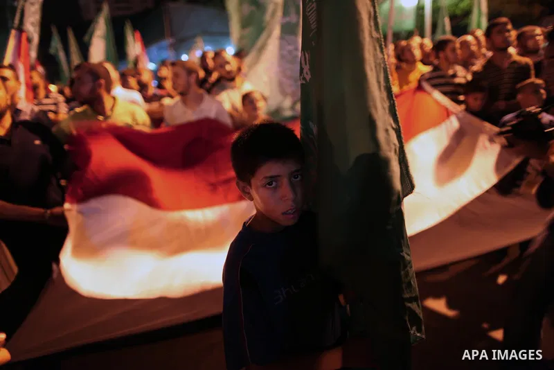 Palestinians hold national and Egyptian flags as they celebrate in Gaza City, the victory of Muslim Brotherhood's presidential candidate, Mohamed Morsi, in the Egyptian elections on June 24, 2012. Arab governments and le...