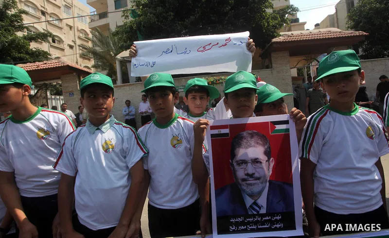 Palestinian boys supporter hold up images for Mohamed Morsi's and palestinian prisoners during celebrations after Muslim Brotherhood's presidential candidate Mohamed Morsi's victory in the Egyptian elections. Palestinian...