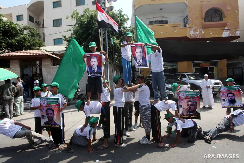 Palestinian boys supporter hold flags of Egypt and Hamas during celebrations after Muslim Brotherhood's presidential candidate Mohamed Morsi's victory in the Egyptian elections, Palestinians gather during a protest in fr...