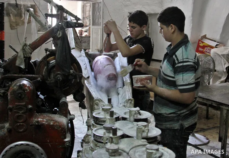 Palestinian labourers work at a factory for making a kind of candy " Toffee" in the West Bank city of Nablus on July 26, 2012. Photo by Nedal Eshtayah
