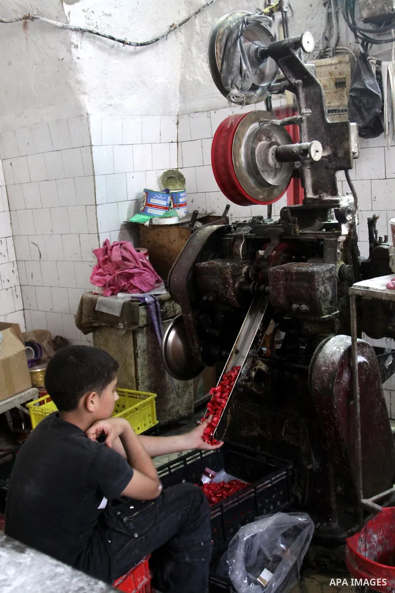 Palestinian labourers work at a factory for making a kind of candy " Toffee" in the West Bank city of Nablus on July 26, 2012. Photo by Nedal Eshtayah