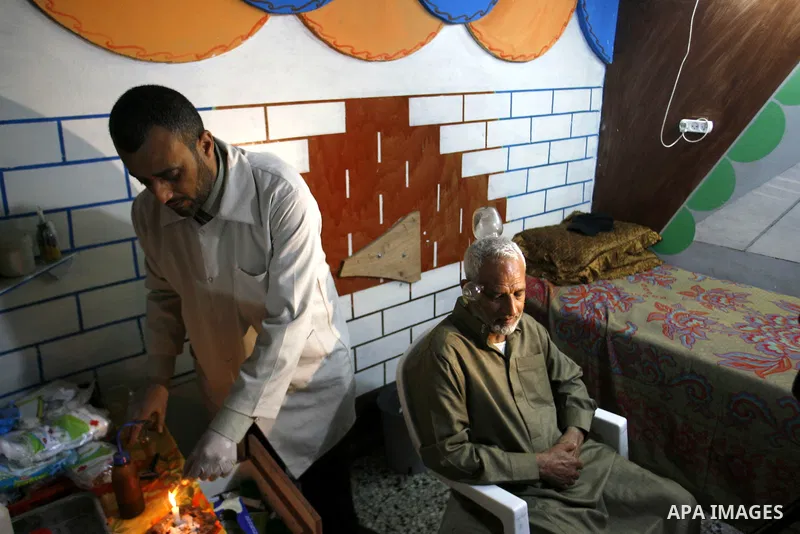 Anwar Sheikh-Eid, 42, performs Hijama or cupping therapy, to Palestinian patient Musa Sheikh El Eid at his shop in the southern Gaza Strip city of Rafah on 27 June 2012. Cupping is an ancient form of alternative medicine...