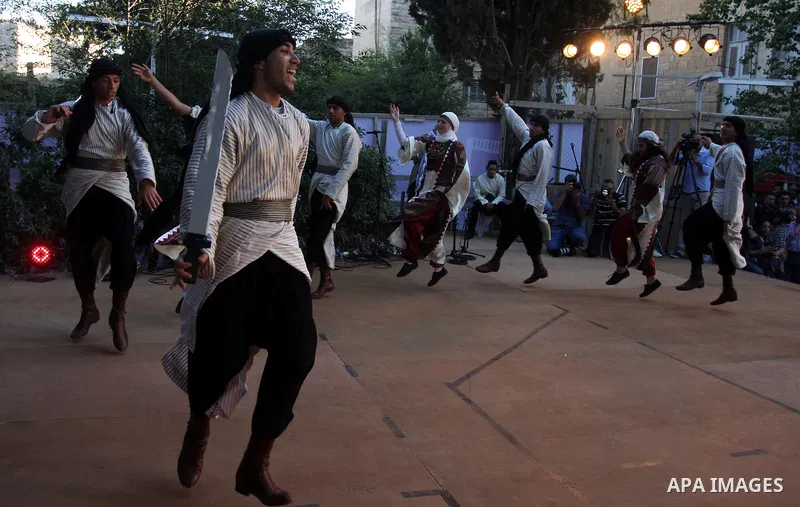 Palestinians perform folk dancing as they take part in a Palestinian wedding, during the opening of the "Heritage Week V in Birzeit 2012" in the old town of Birzeit in Ramallah, West Bank, 27 June 2012. Photo by Issam Ri...
