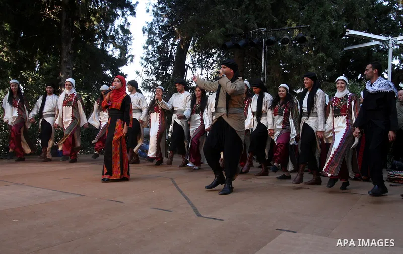 Palestinians perform folk dancing as they take part in a Palestinian wedding, during the opening of the "Heritage Week V in Birzeit 2012" in the old town of Birzeit in Ramallah, West Bank, 27 June 2012. Photo by Issam Ri...