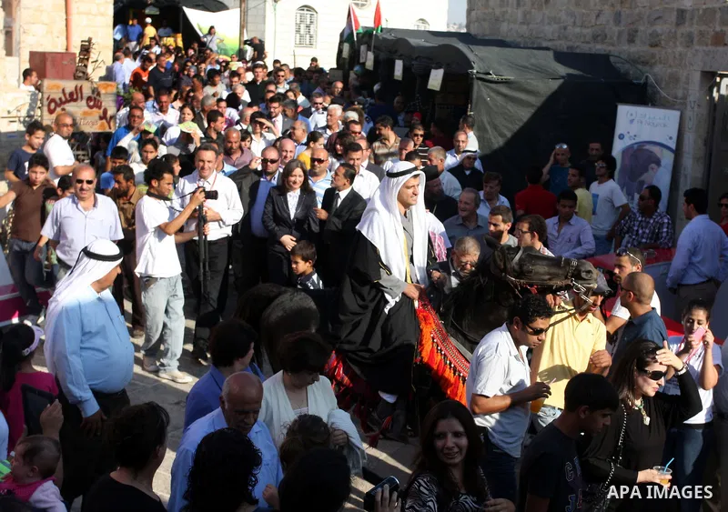 Palestinians sing folk songs as they take part in a Palestinian wedding, during the opening of the "Heritage Week V in Birzeit 2012" in the old town of Birzeit in Ramallah, West Bank, 27 June 2012. Photo by Issam Rimawi