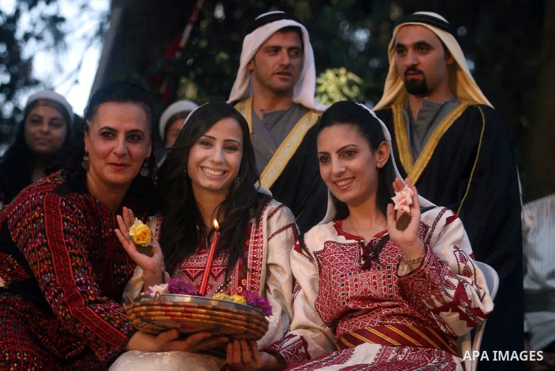 Palestinian brides show Henna patterns on their hands as they take part in a Palestinian wedding, during the opening of the "Heritage Week V in Birzeit 2012" in the old town of Birzeit in Ramallah, West Bank, 27 June 201...