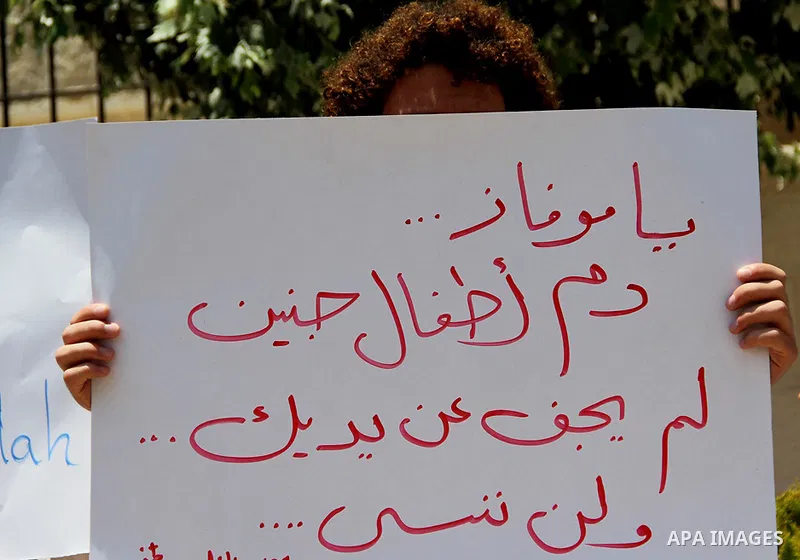 A Palestinian protestor holds a signe bearing slogans against the upcoming visit of Israeli vice prime minister Shaul Mofaz to the West Bank city of Ramallah for a meeting with Palestinian president Mahmud Abbas, outside...