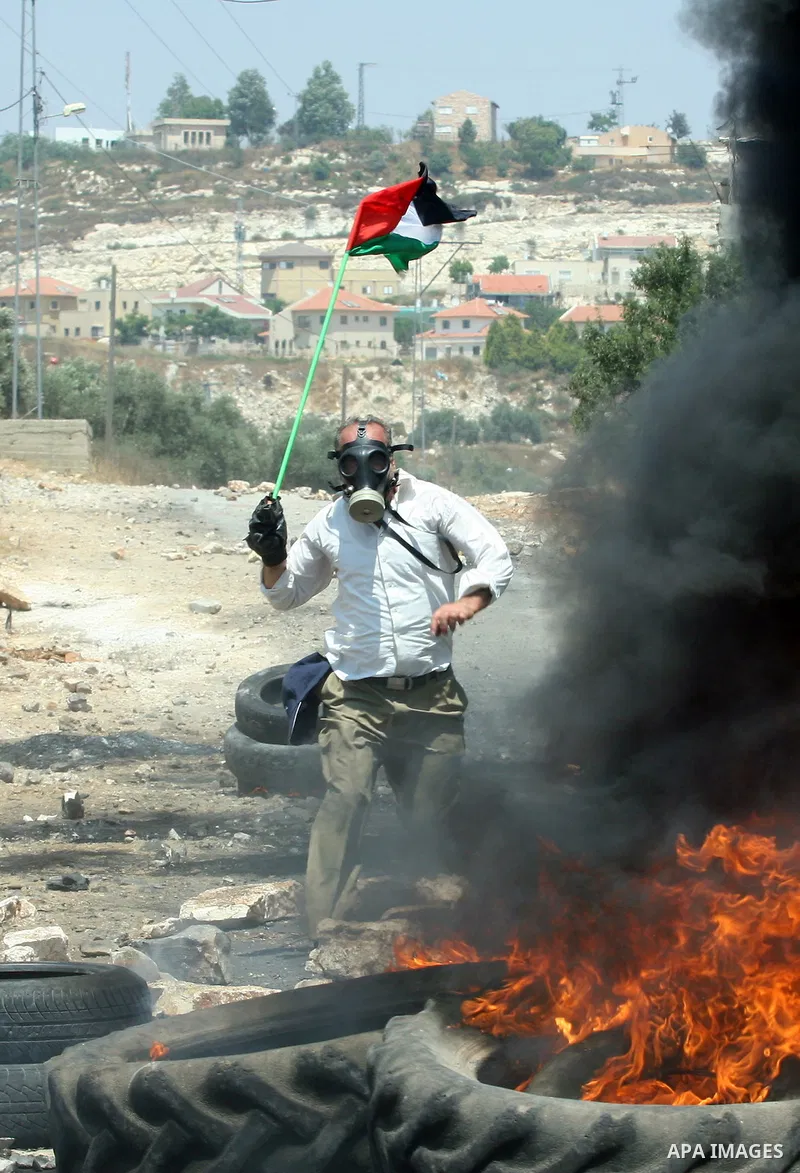 A Palestinian protestor throws stones during clashes with Israeli troops following a weekly protest against the Jewish settlement of Kdumim, near Nablus,in the northern West Bank village of Kufr Qaddum, June 29, 2012. Ph...