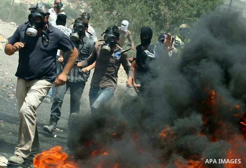 Palestinian protestors throw stones during clashes with Israeli troops following a weekly protest against the Jewish settlement of Kdumim, near Nablus,in the northern West Bank village of Kufr Qaddum, June 29, 2012. Phot...
