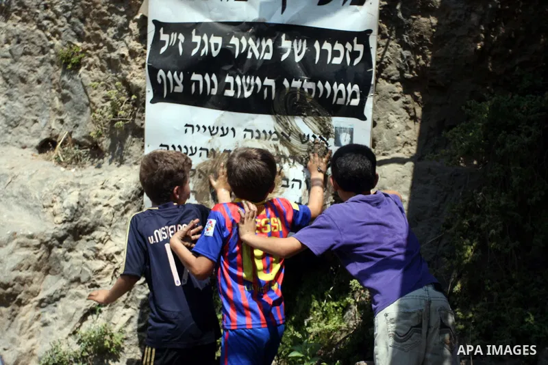 Palestinian children remove an Israeli banner during a demonstration against Israel's separation barrier in the West Bank village of Nabi Saleh near Ramallah, , Friday, June 29, 2012. Palestinians protest weekly against...