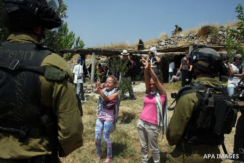 Israeli soldiers confront Palestinian children during a demonstration against Israel's separation barrier in the West Bank village of Nabi Saleh near Ramallah, Friday, June 29, 2012. Palestinians protest weekly against t...